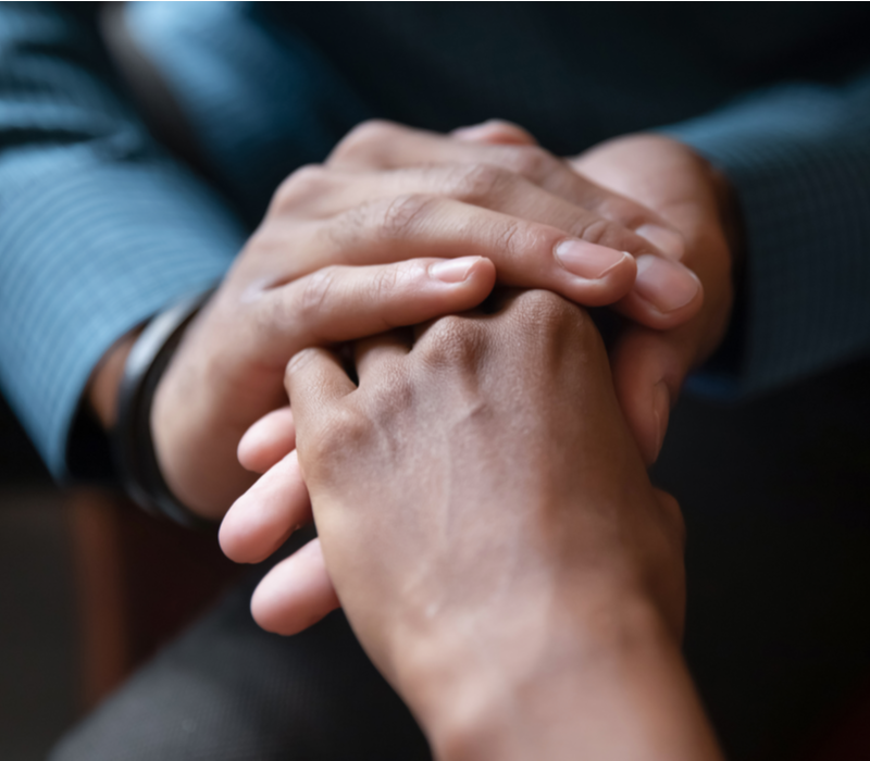 Close-up of two adults holding hands