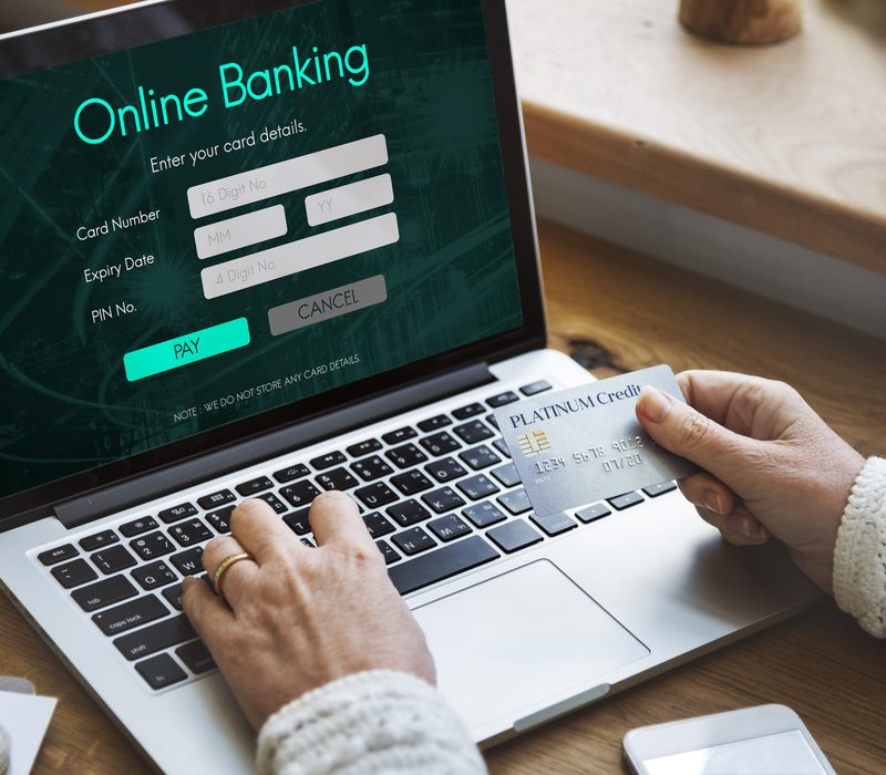 Someone using a laptop that says “online banking” on the screen