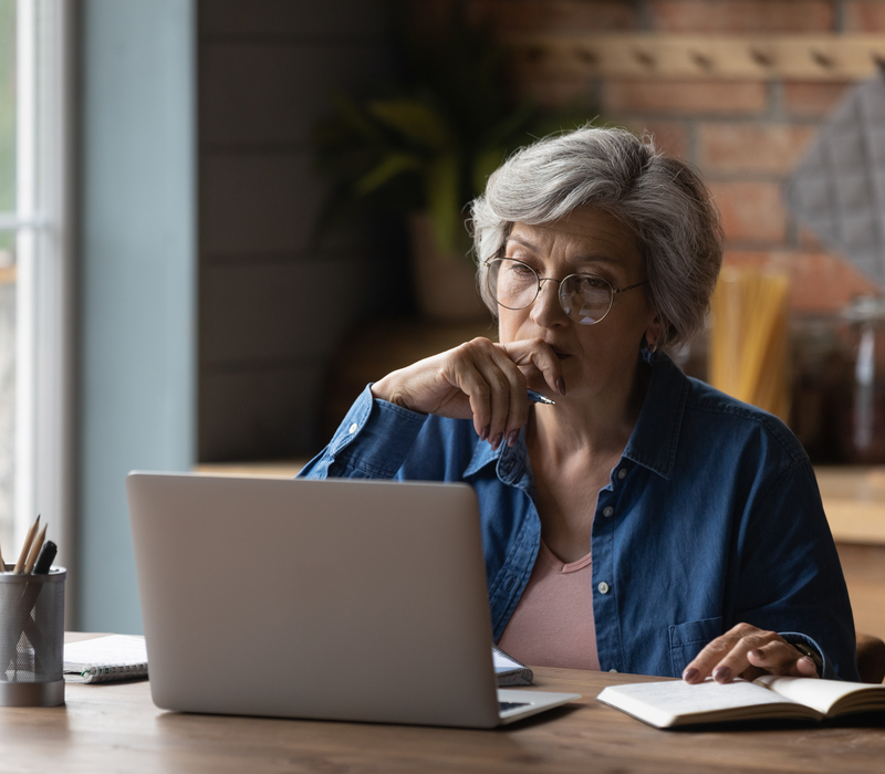 A woman sitting at a table with a laptop