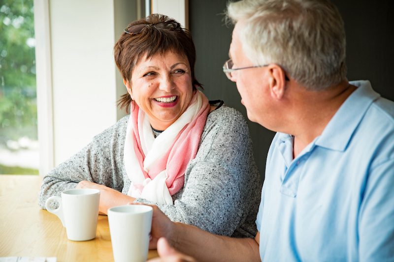 Senior couple in love sitting in cafe, drinking coffee, talking, laughing and having fun. Happy people in retirement concept. RMI Independent Financial Advice Market Harborough