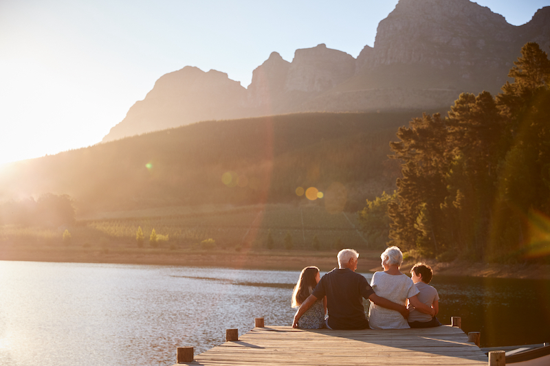 Children sitting with their grandparents on a jetty