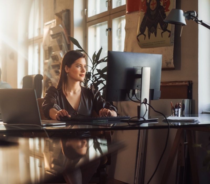 A woman using a computer in an office.